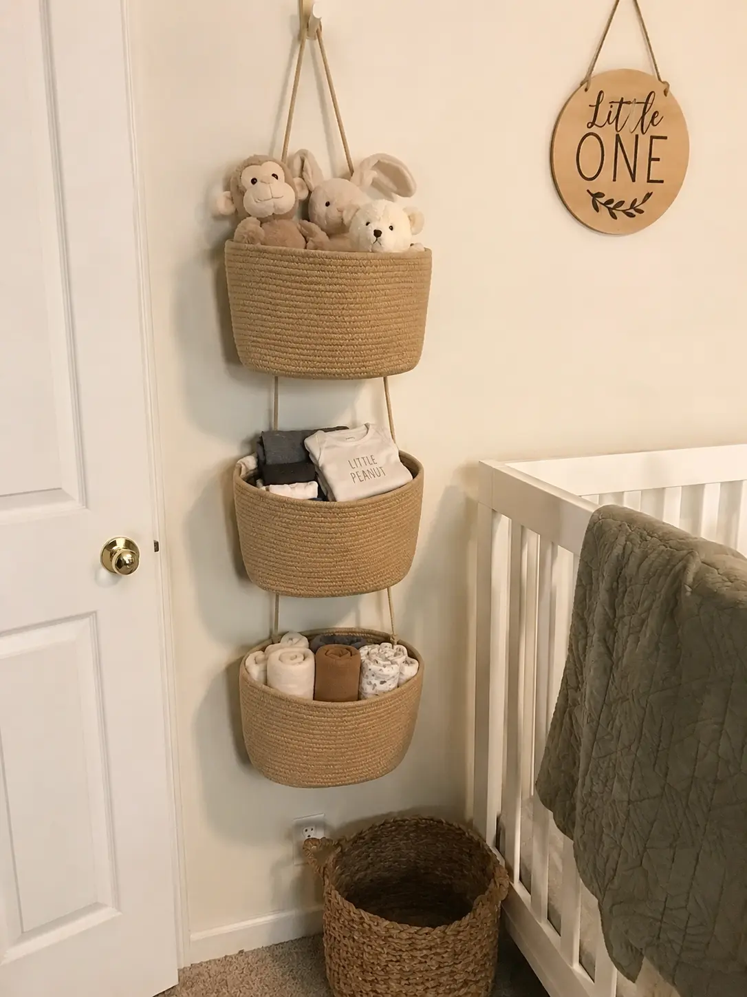 Hanging basket used in a nursery holding stuffed animals and folded baby clothes