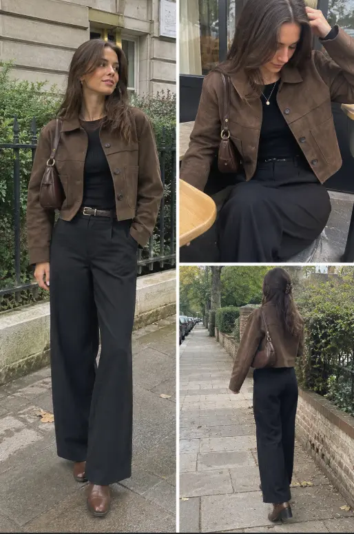 Woman wearing a brown suede jacket with a fitted black top, black wide-leg pants, brown ankle boots, and a brown shoulder bag.